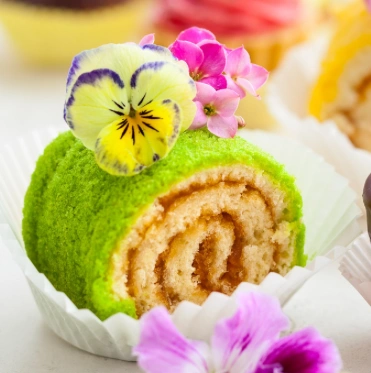 Cake Roll verde esponjoso decorado con flores comestibles